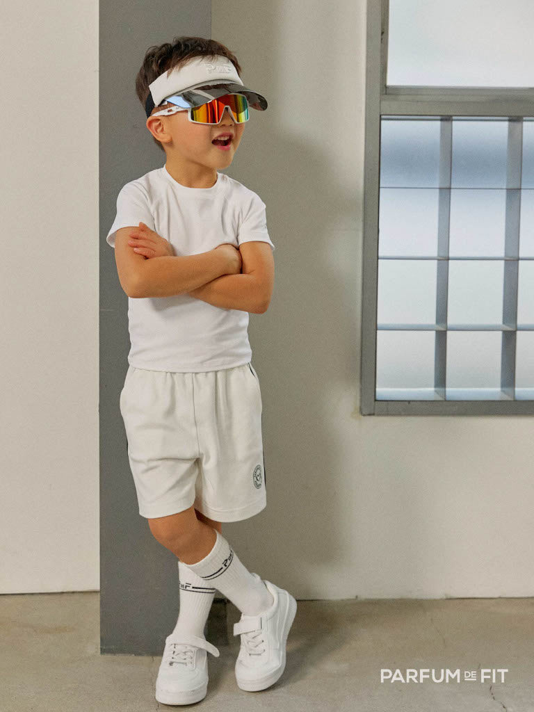 Boy wearing white Parfum de Fit activewear with visor and sunglasses